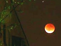 Lunar eclipse.
      Moon is reddish, not deep black.