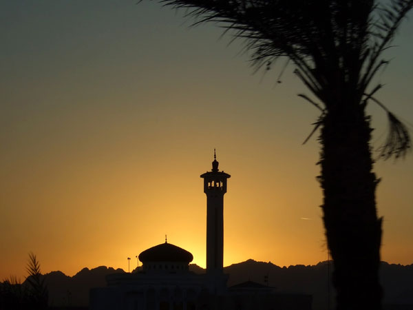 Чёрный силуэт мечети и минарета
      на фоне заката