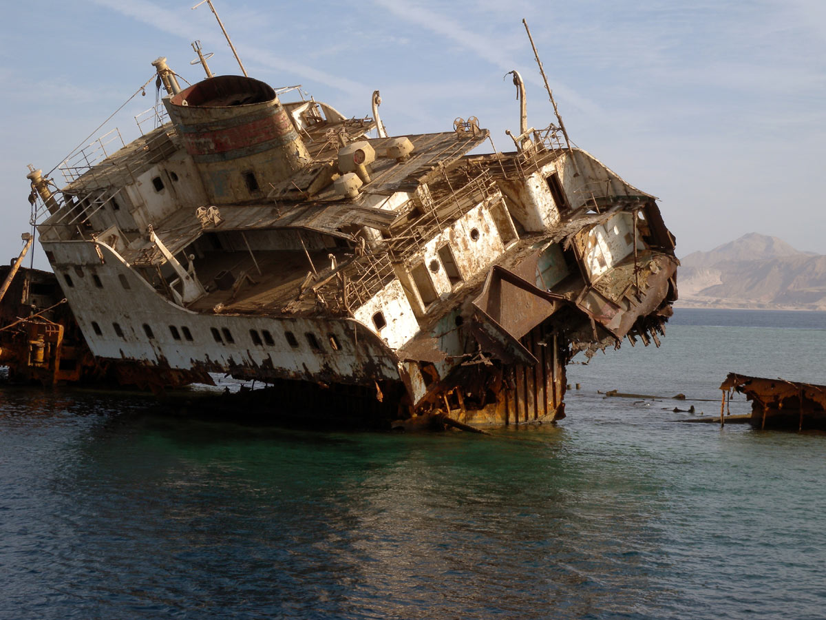 A broken rusty ship on a coral
      reef