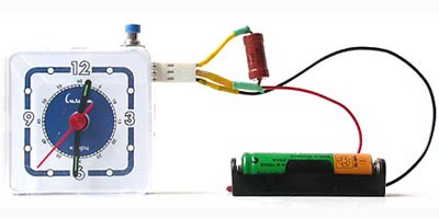 Устройство для измерения ёмкости аккумуляторов состоит из схемы внутри часов и держателя батареи.